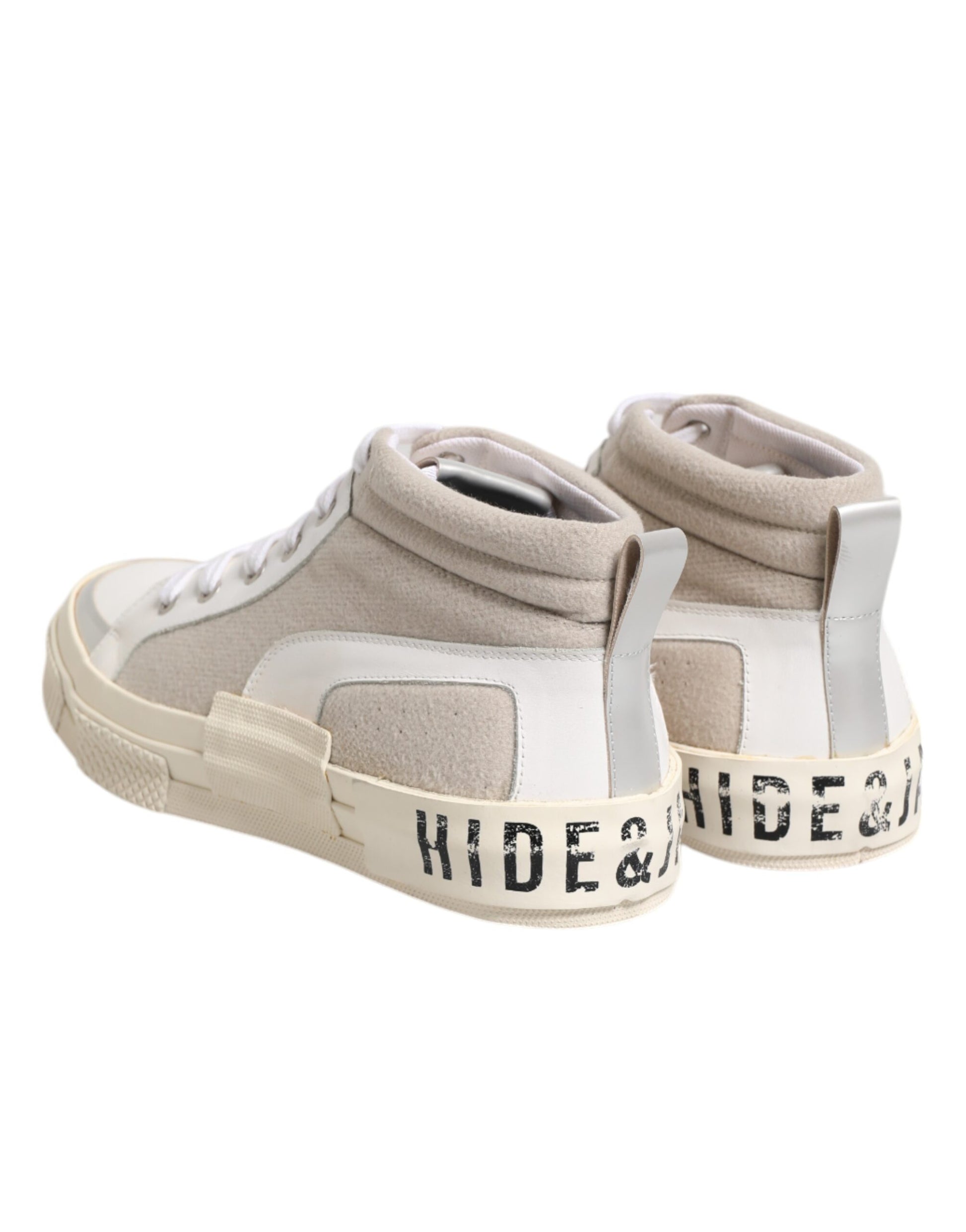 Tan sneakers with white laces and a black logo on the side