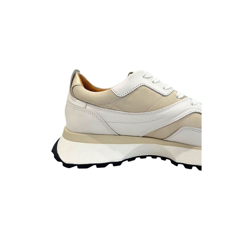 A white leather men's sneaker with a tan sole, featuring laces and a low top design