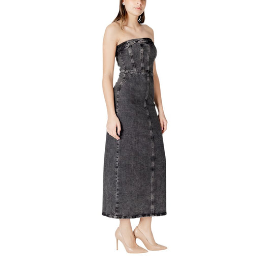 A black cotton midi dress with a fitted bodice and flared skirt, worn by a model on a plain background