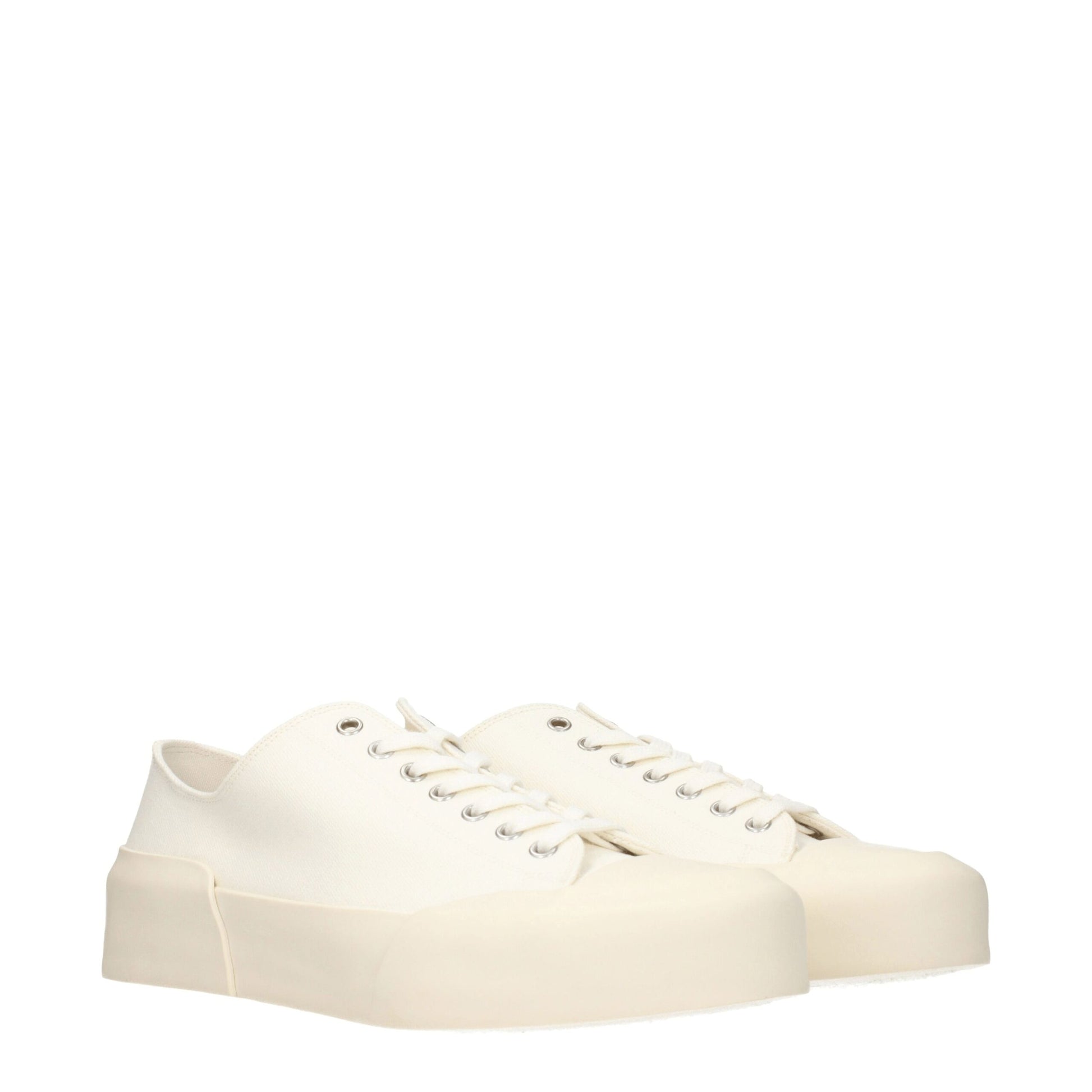 Tan canvas low top sneakers with white laces, elastic panels and a chunky sole