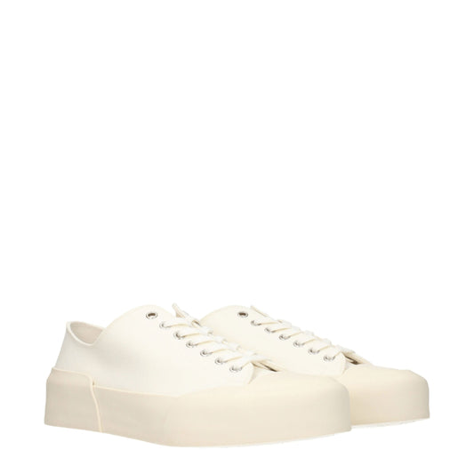 Tan canvas low top sneakers with white laces, elastic panels and a chunky sole