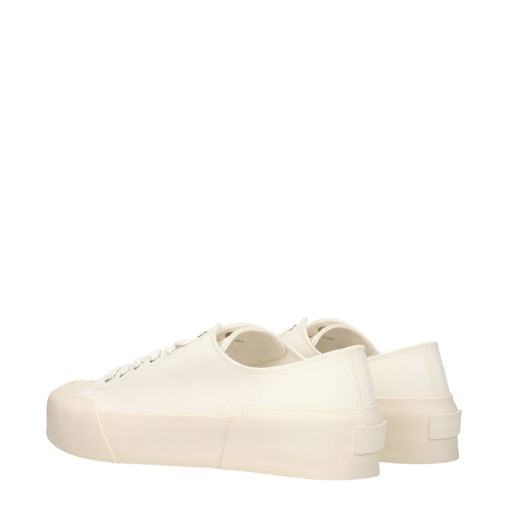 Pair of beige fabric low top sneakers with white laces and a small logo on the side
