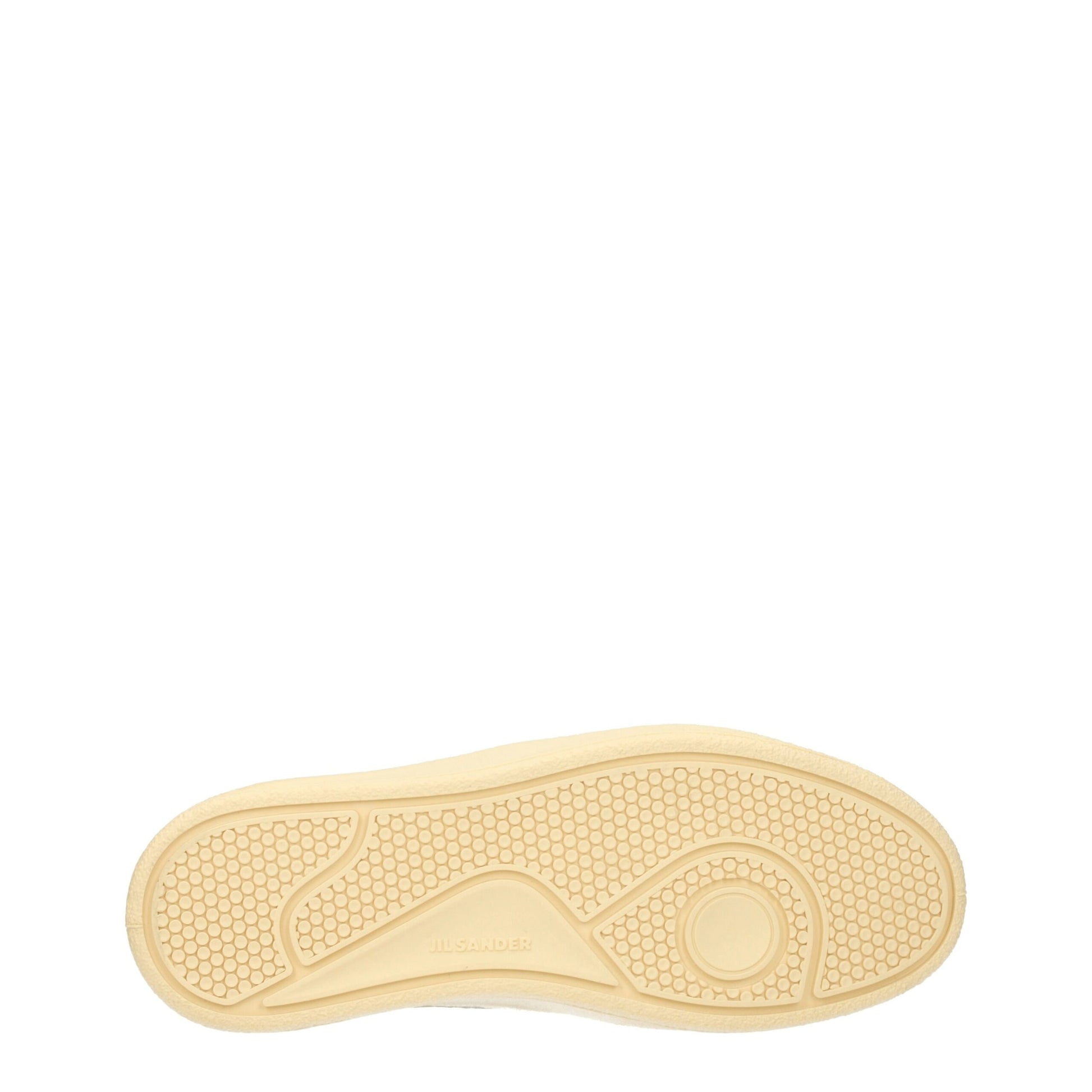 A single white leather sneaker with a low top, featuring a textured sole and a small circular logo on the side