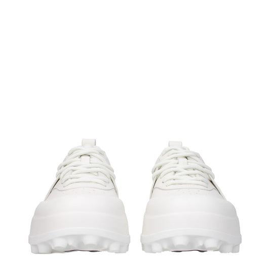 Pair of white leather sneakers with laces, featuring a low-top design and flat soles
