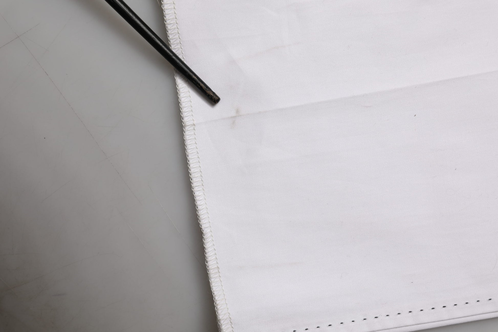 A pair of white cotton stretch dress pants with a button and zipper closure