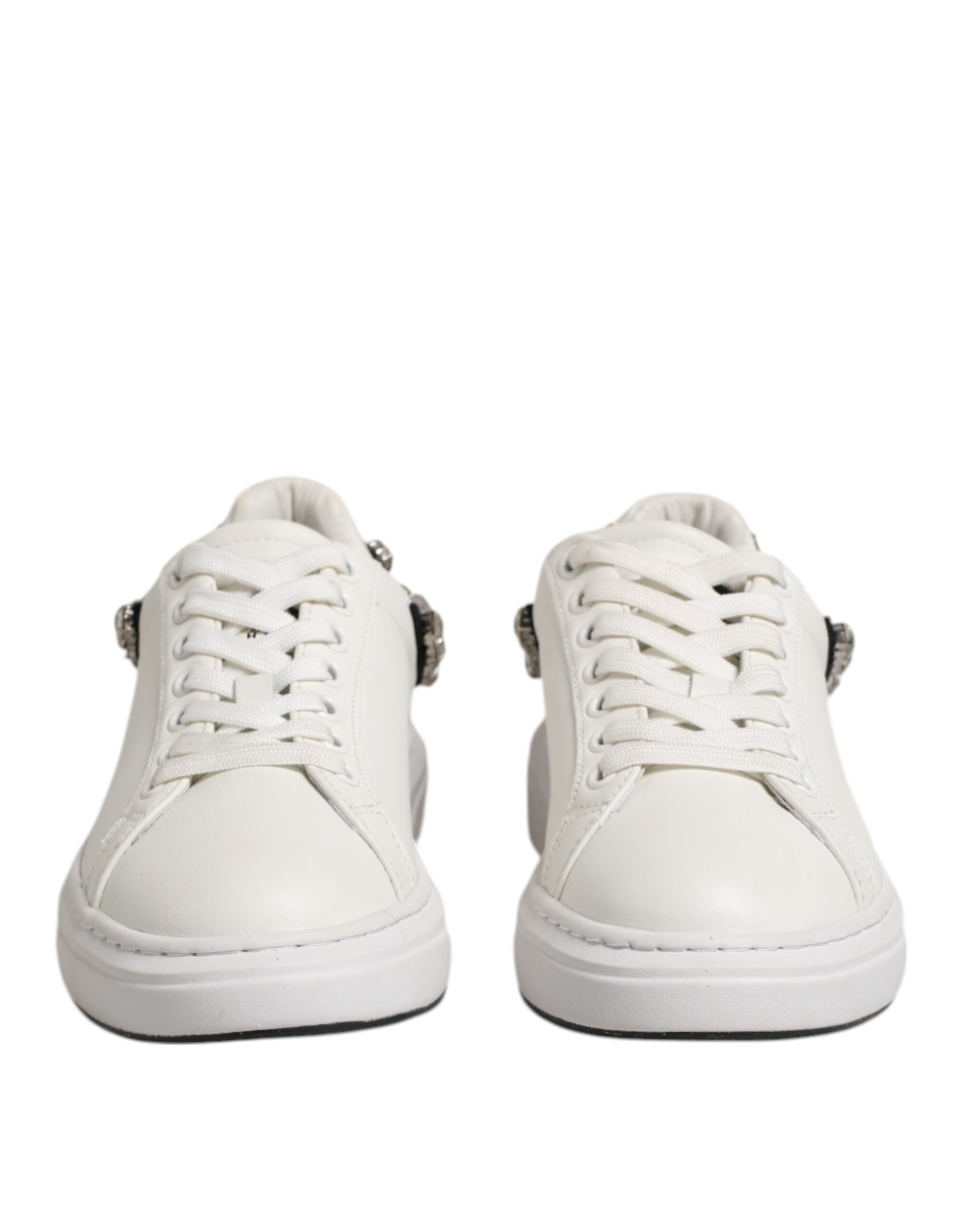 Pair of white sneakers with rhinestones on sides, lace-up design, and embellishments