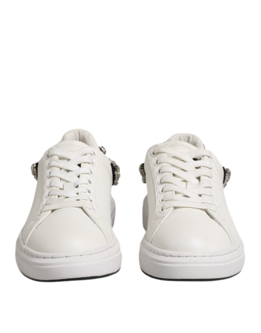 Pair of white sneakers with rhinestones on sides, lace-up design, and embellishments