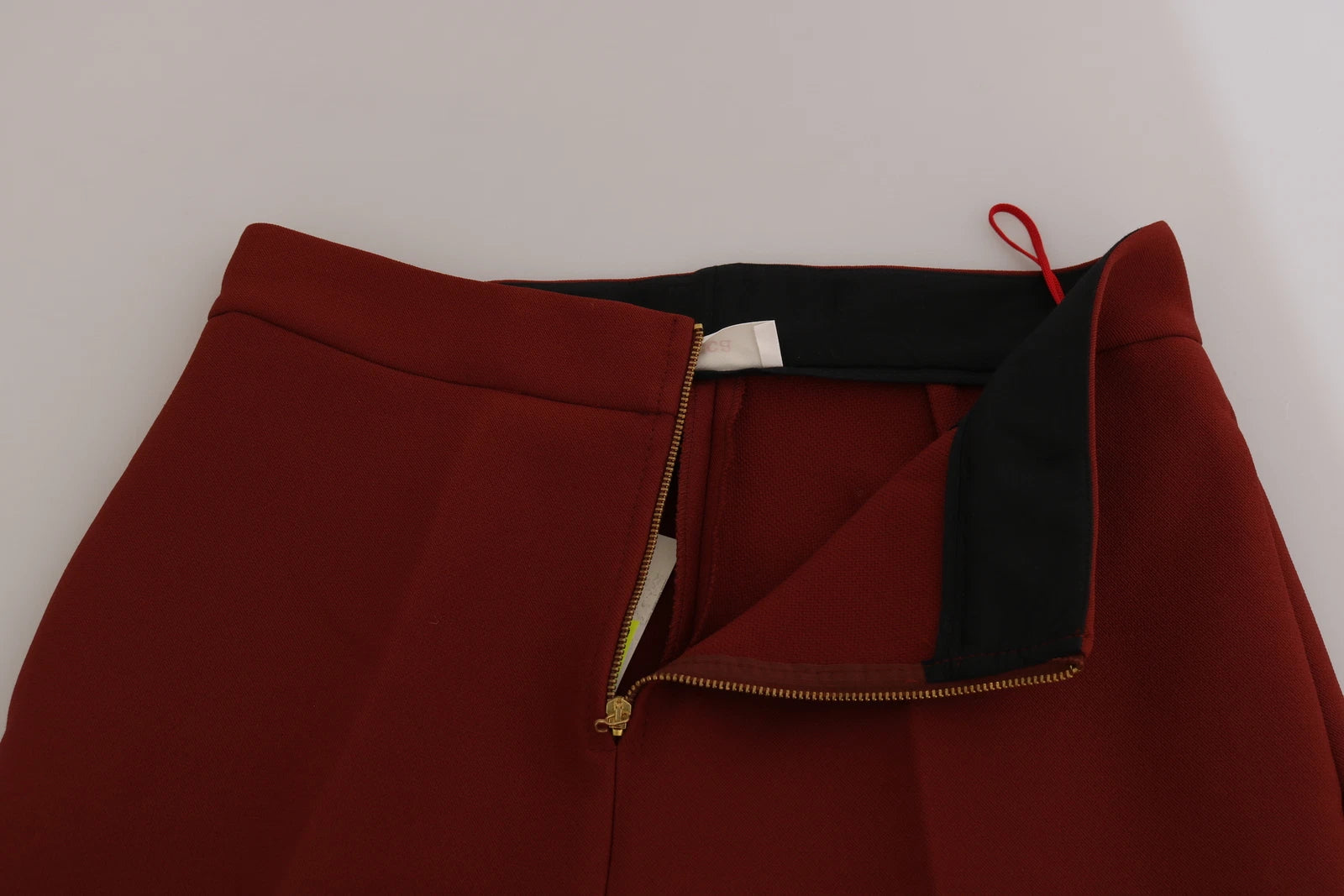 A pair of red high waist cropped flared dress pants with a zipper on the front