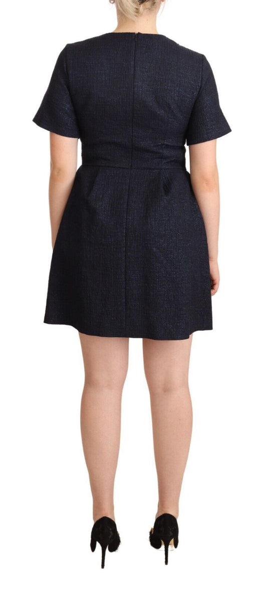 The back view of a woman wearing a dark blue dress with short sleeves and a high neckline