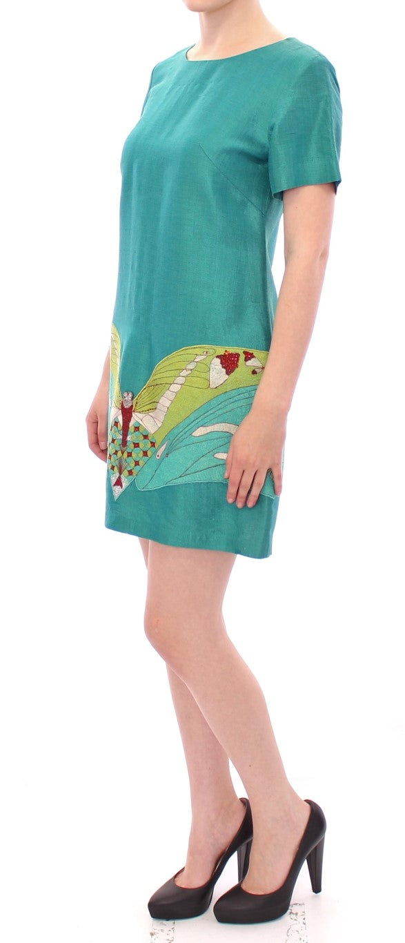 Woman wearing a green dress with floral pattern on front