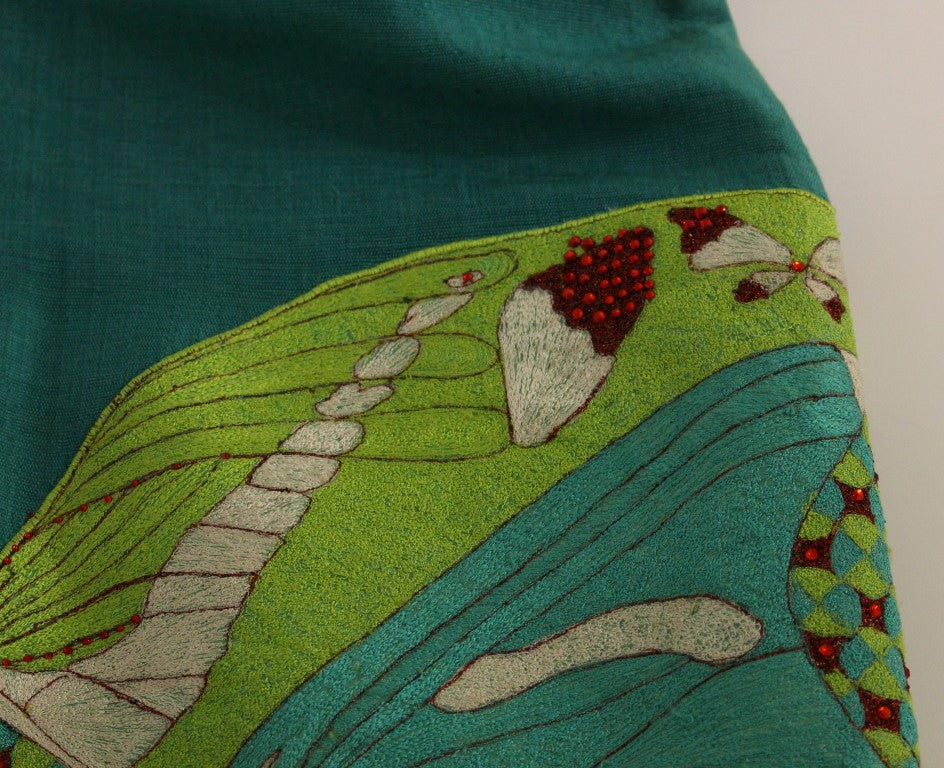 Embroidered green fabric with a design of a dragonfly on a riverbank