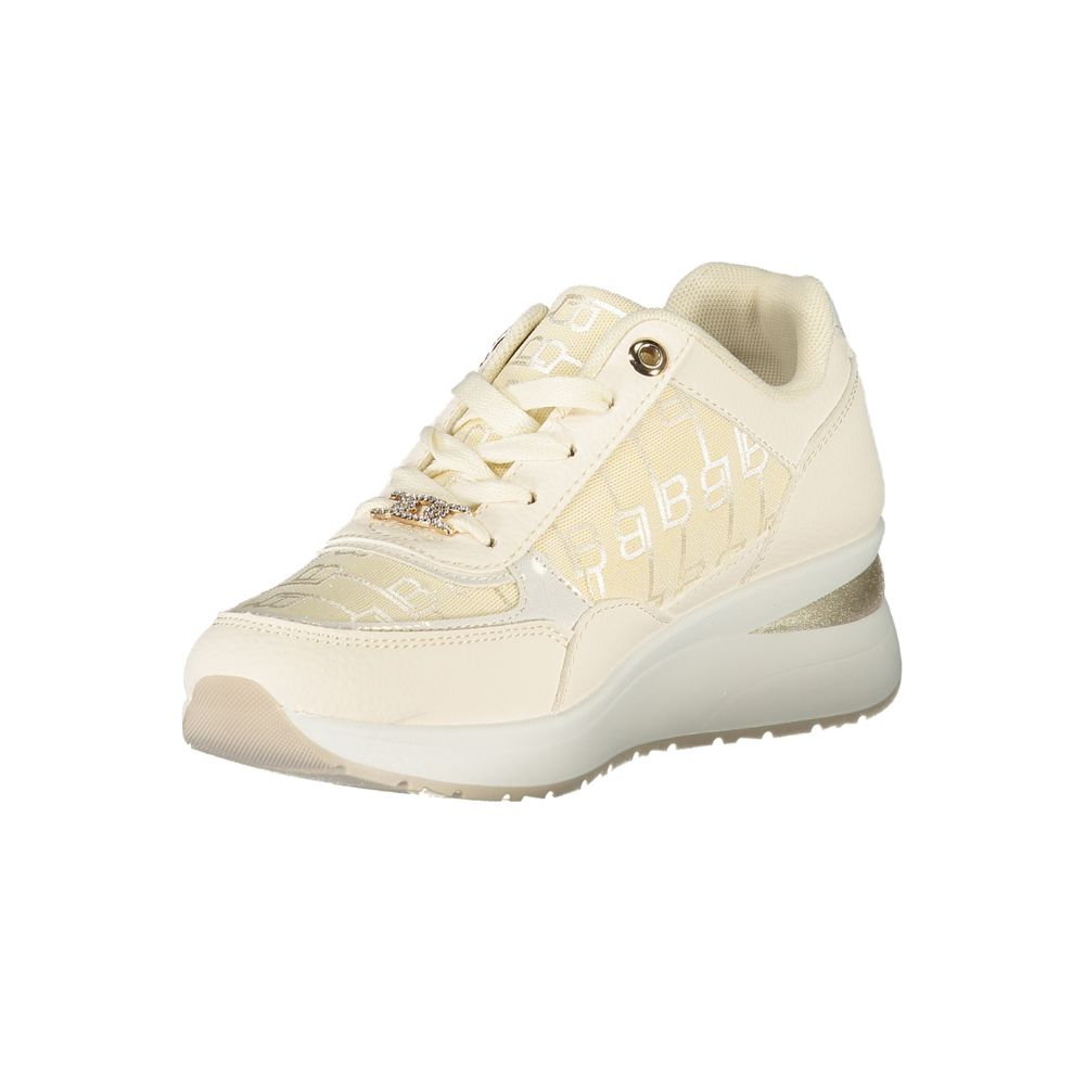 A white women's sneaker with a gold buckle, featuring a textured upper and a flat sole