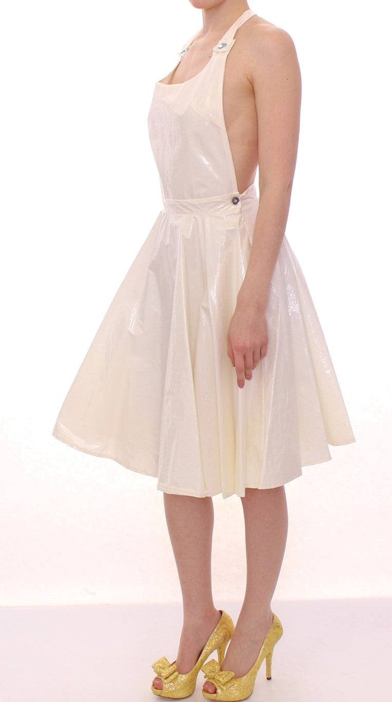 Woman wearing a white dress with a high neckline and yellow heels