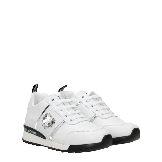 White leather low top sneakers with black laces, featuring a gold buckle and logo on the side