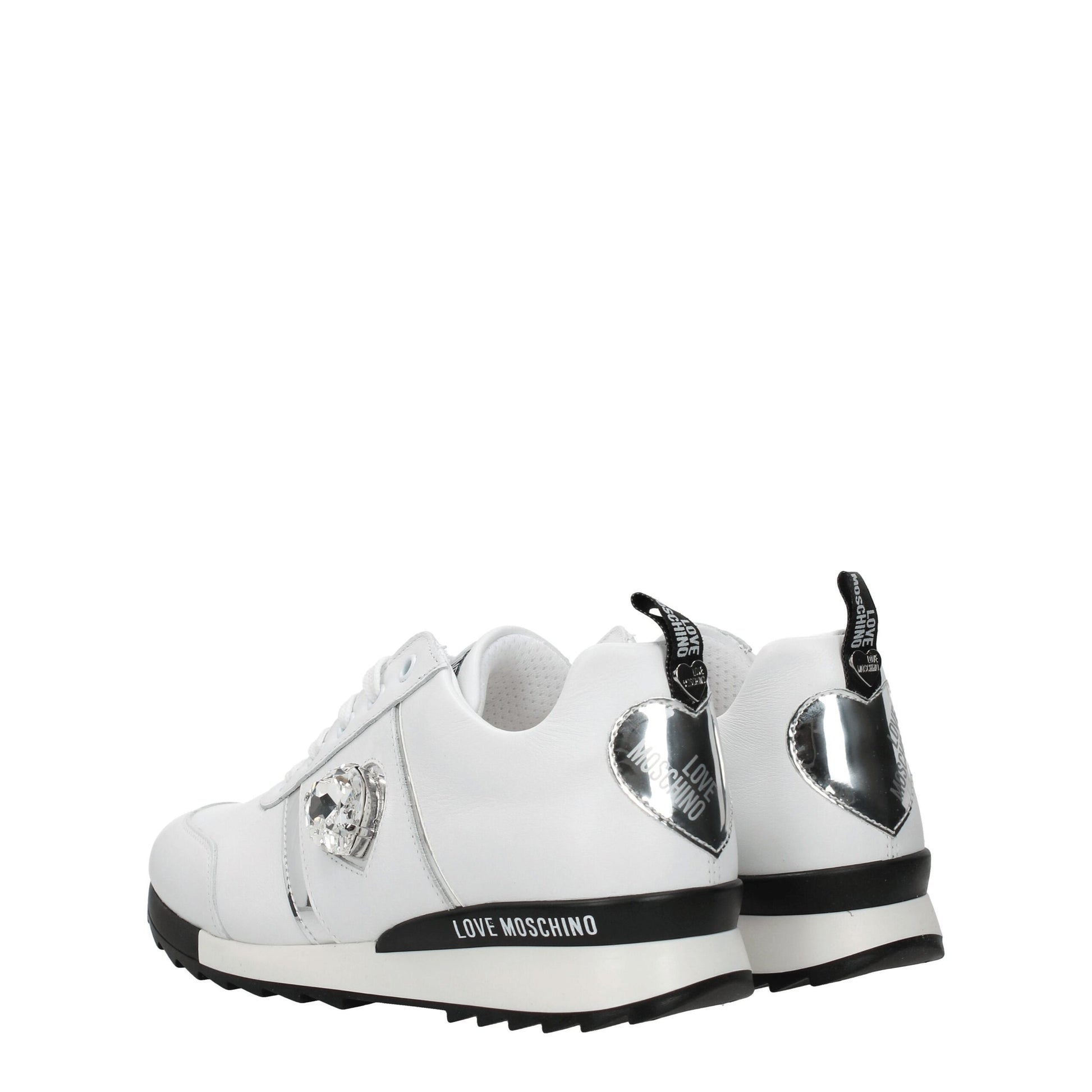 White leather low top sneakers with black laces, featuring a silver buckle and the brand name on the side