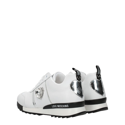 White leather low top sneakers with black laces, featuring a silver buckle and the brand name on the side