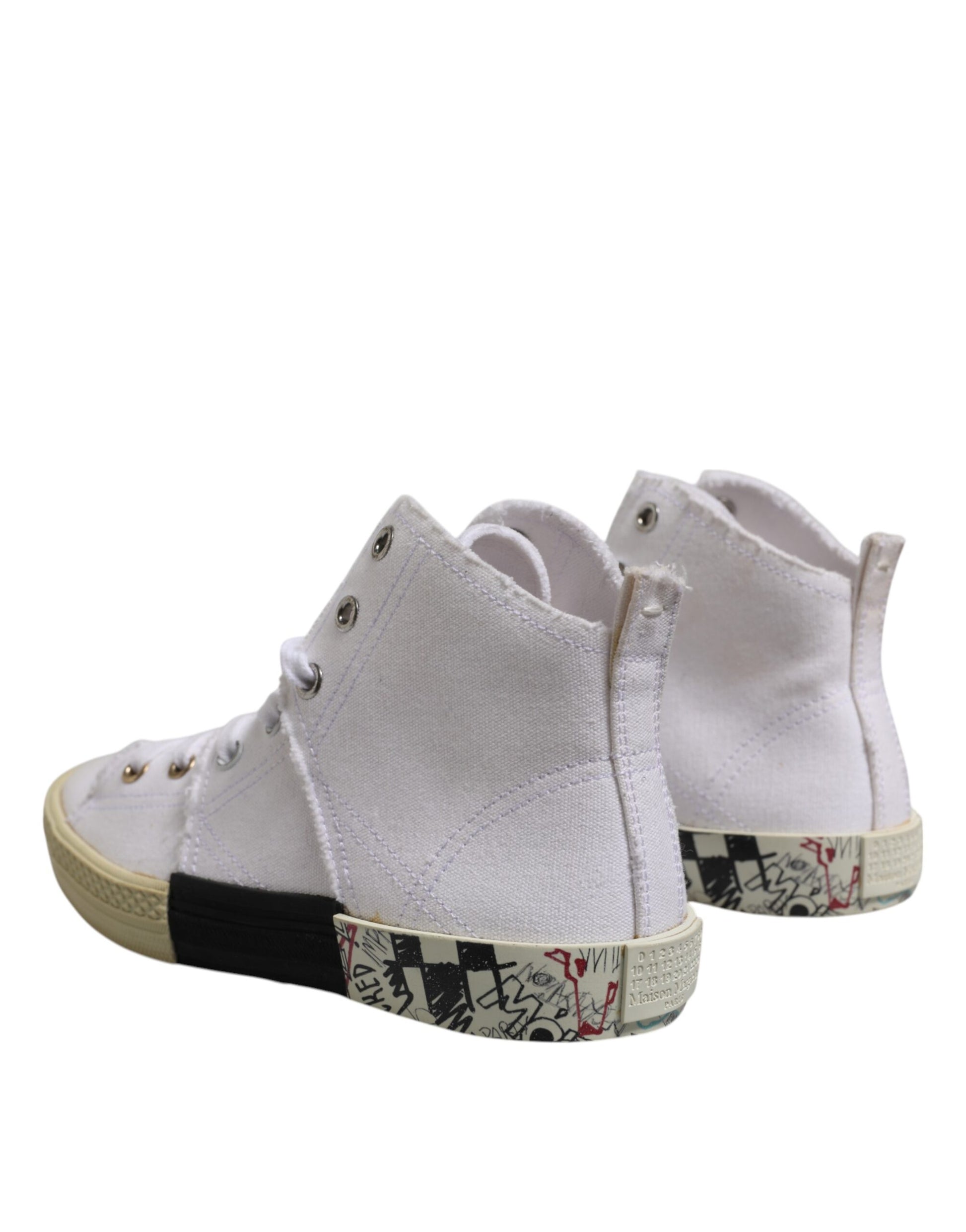 Pair of white sneakers with black laces and patterned sole