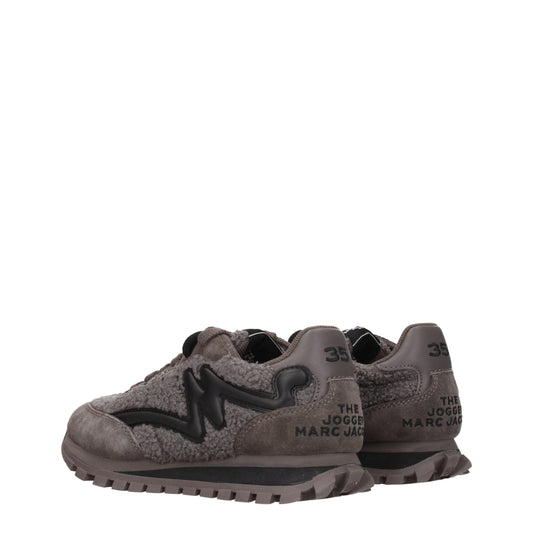 Pair of gray chunky sneakers with white text and logo, featuring a fur-like texture on the upper part
