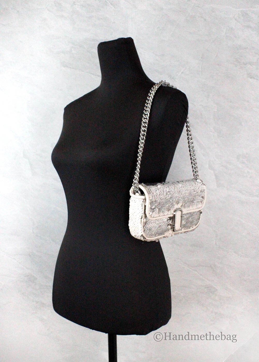 Silver purse on black mannequin