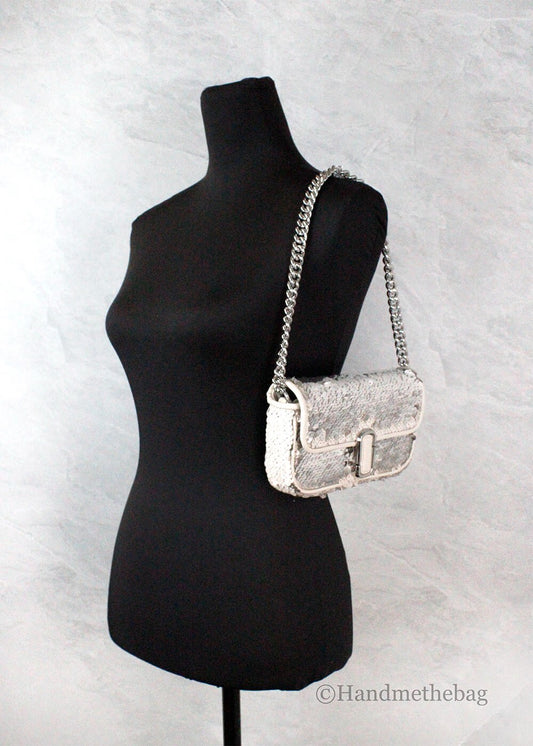 Silver purse on black mannequin
