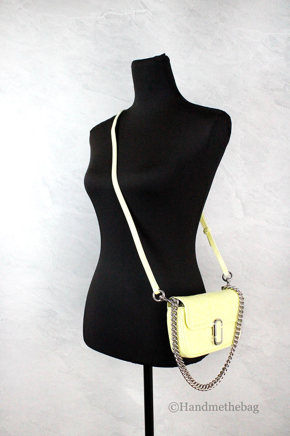 Yellow crossbody bag on black mannequin