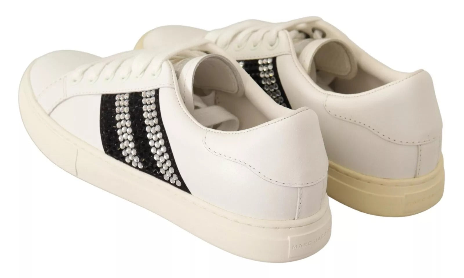 White sneakers with black stripes and gold accents