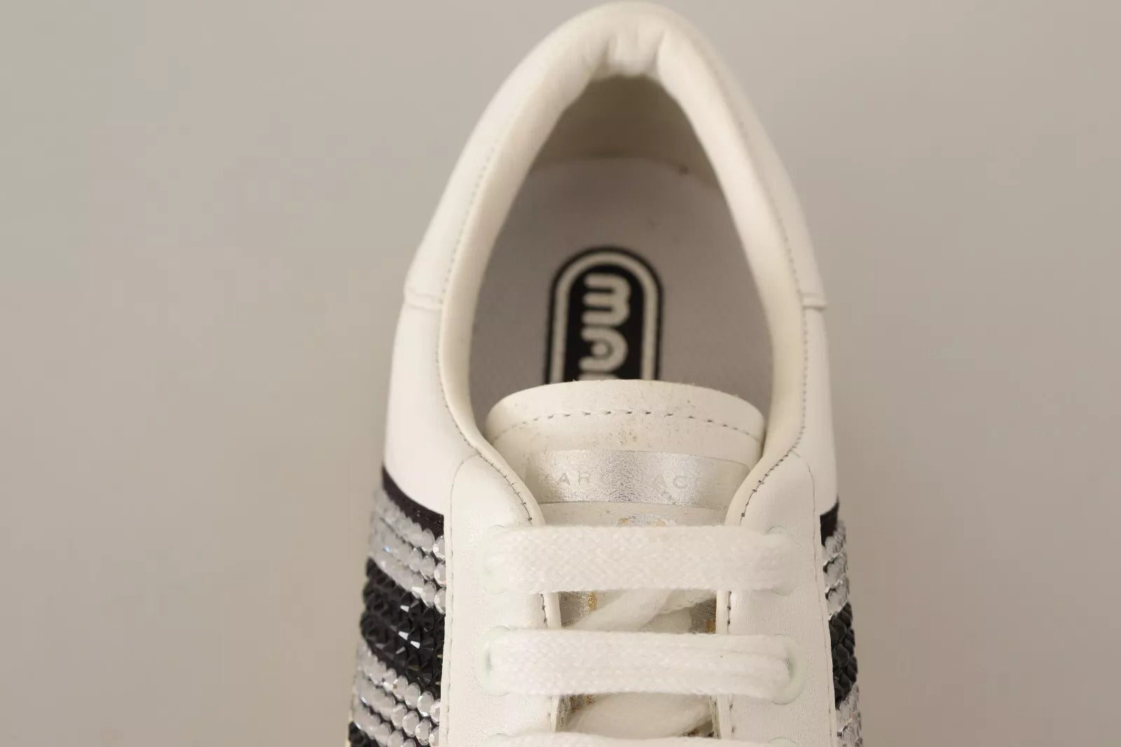 White sneaker with black laces and sole