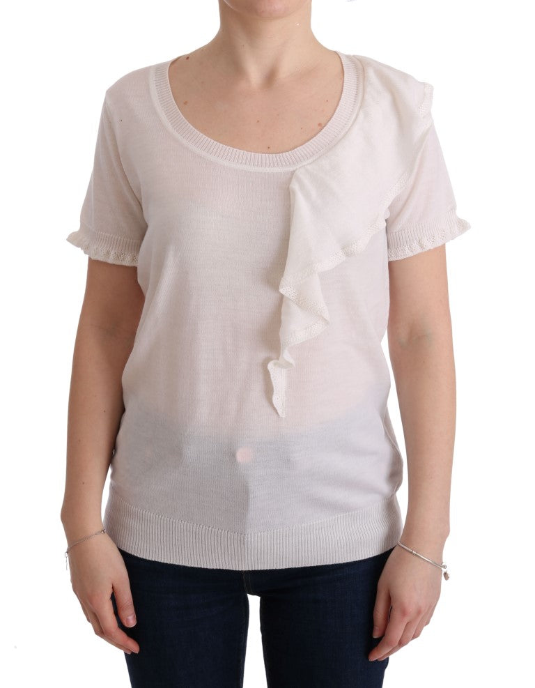 Woman wearing a white long sleeve shirt with ruffled cuffs