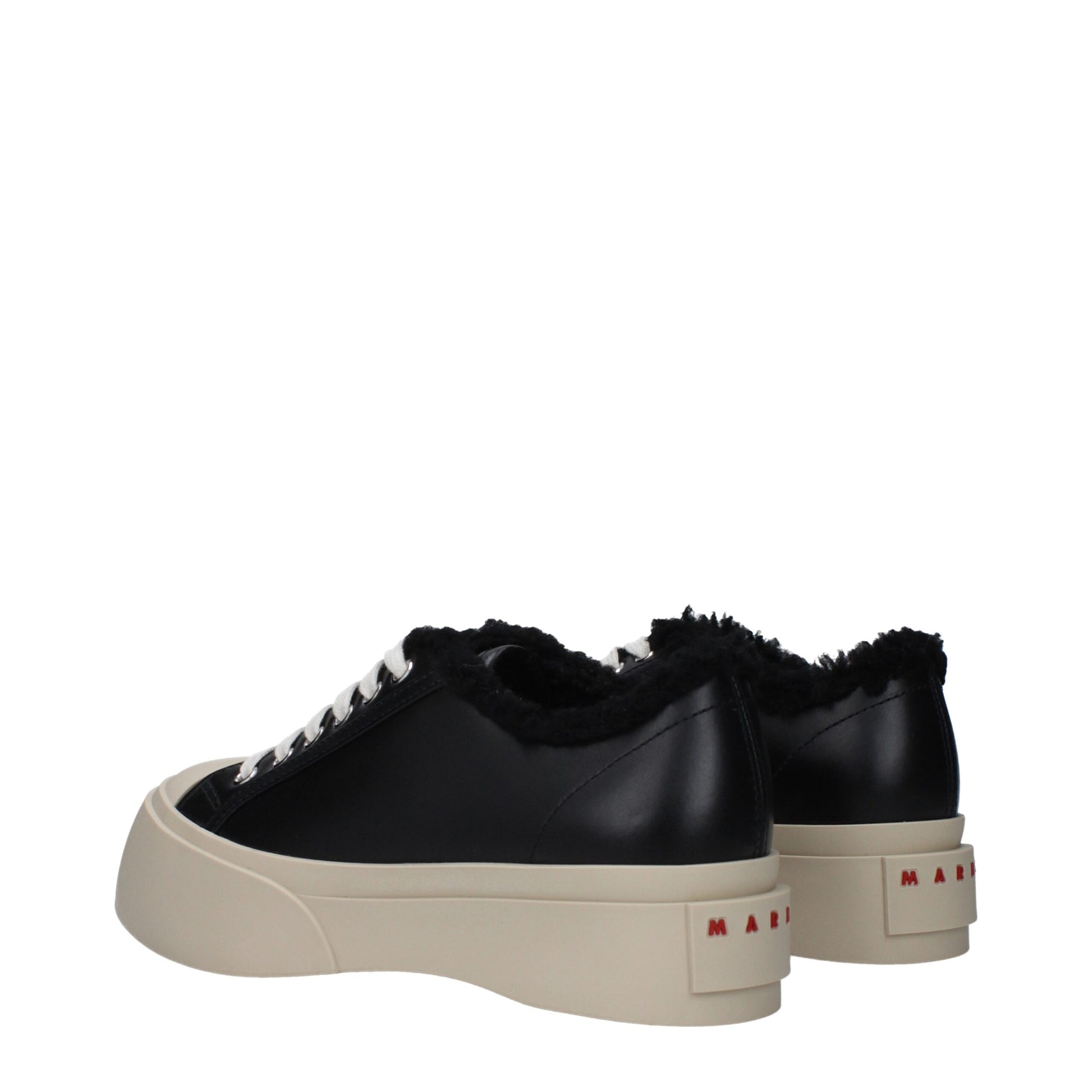 Pair of black leather chunky sneakers with white laces, tan soles and red branding on the side