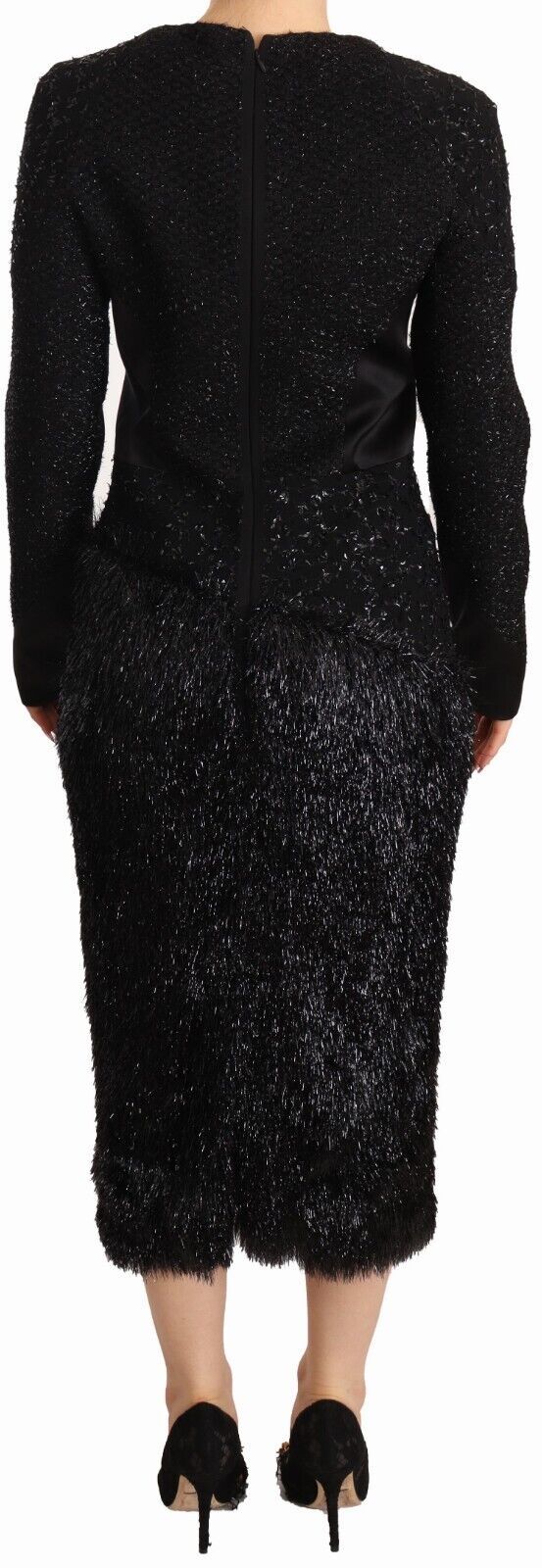 A black dress with long sleeves, embellished with studs and featuring a sheath silhouette