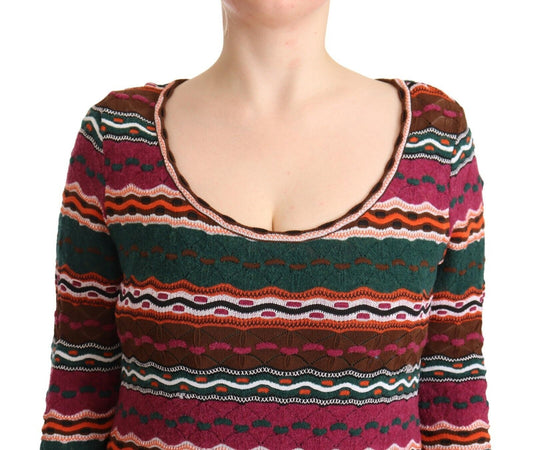 A woman wearing a multicolored striped knit dress with long sleeves