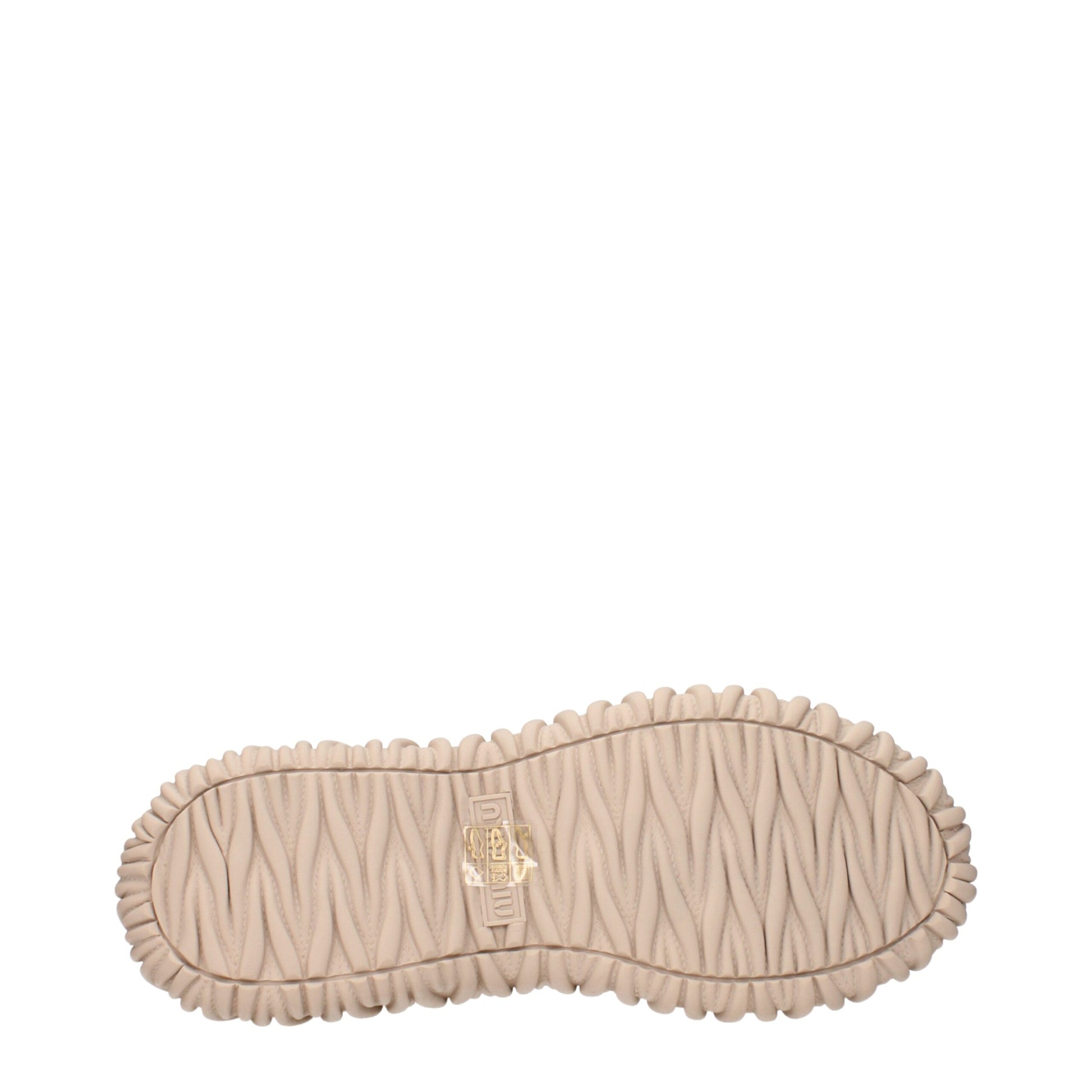 A beige fabric slip on shoe with a textured sole, featuring a gold logo on the heel