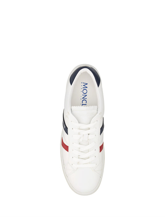 A pair of white sneakers with red accents, featuring a low top design