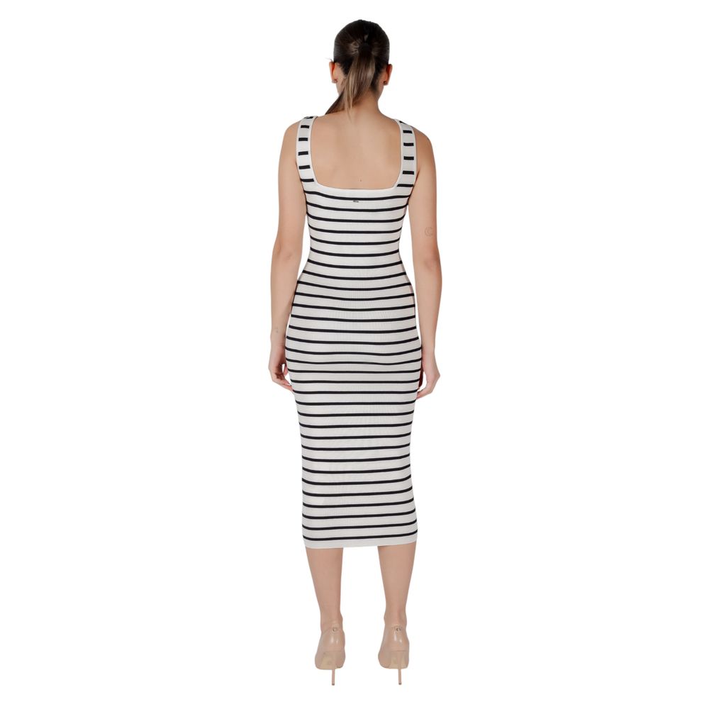 A woman wearing a black and white striped dress with short sleeves
