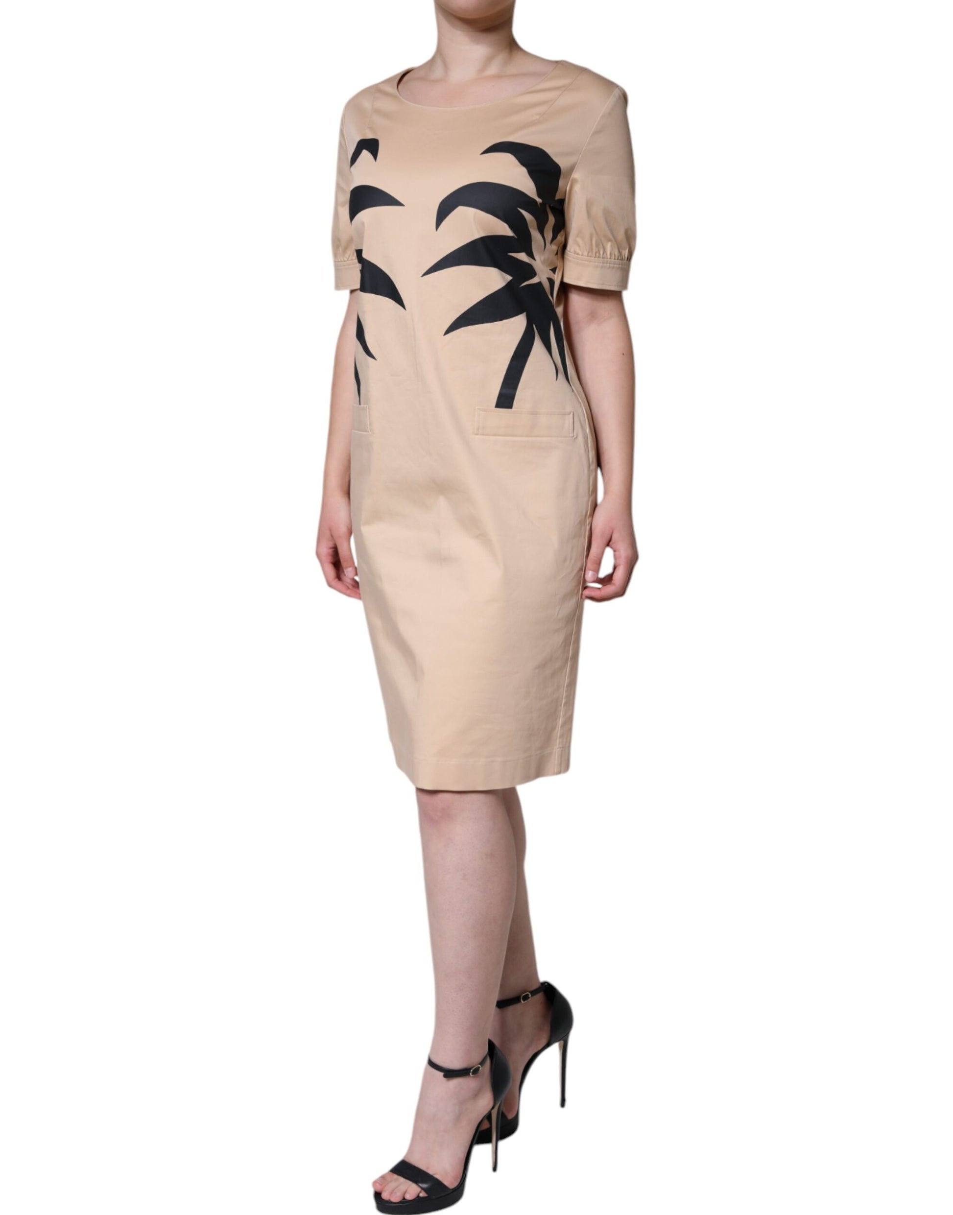 Woman wearing a beige dress with palm tree design