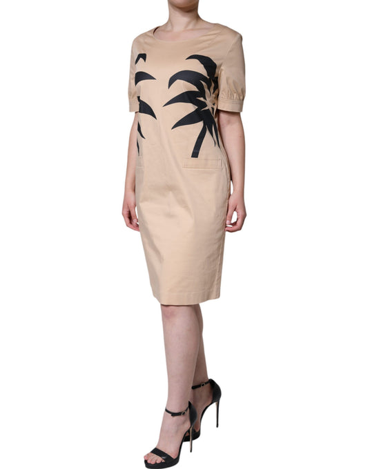 Woman wearing a beige dress with palm tree design