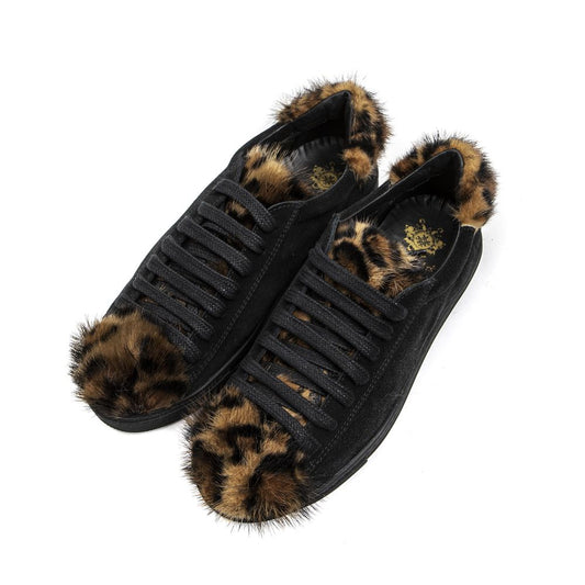 A pair of black leather women's sneakers with fur trim on the bottom and a textured sole