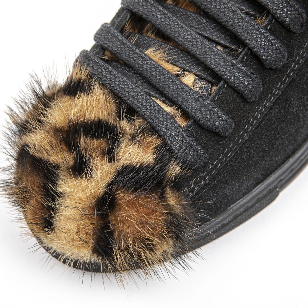 A black leather women's sneaker with a furry, brown and white patterned toe cap