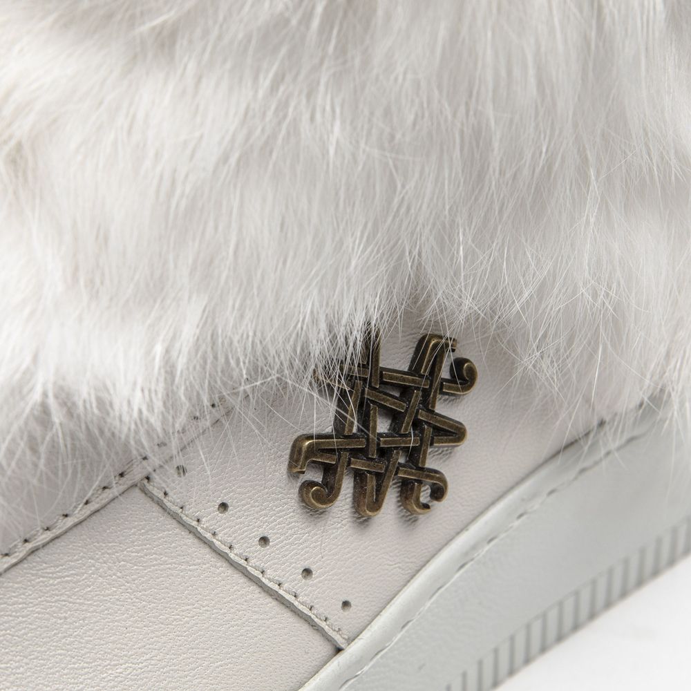 A white sneaker with a gold cross design on the side