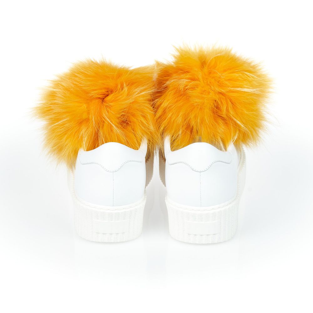 A pair of white sneakers with fur pom poms