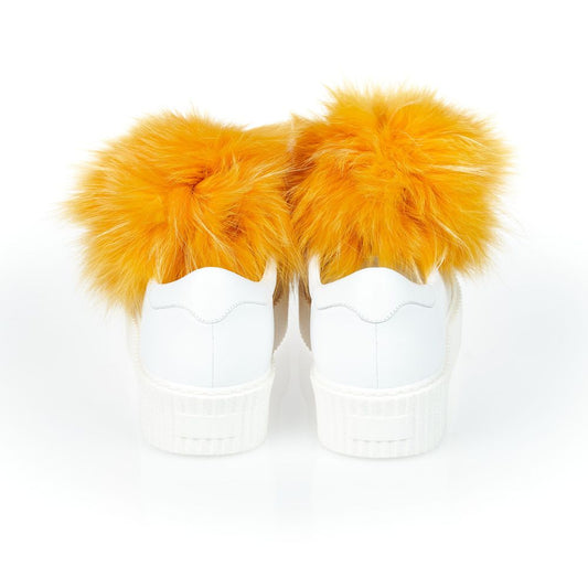 A pair of white sneakers with fur pom poms