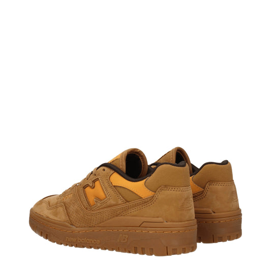 Pair of brown leather sneakers with white laces, featuring a logo on the side and a flat sole