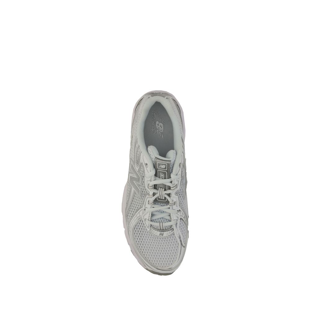 A single white athletic shoe with a pink logo on the side, featuring laces and a textured sole