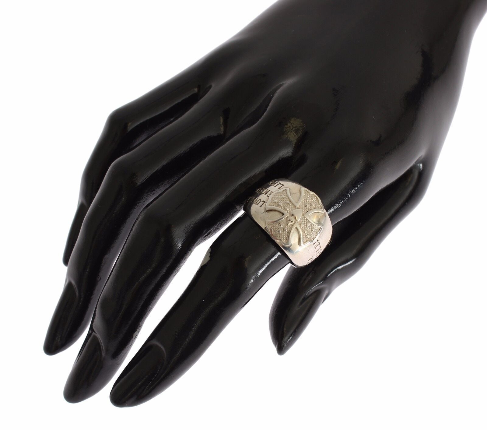 Hand wearing ring with gold design on black mannequin hand