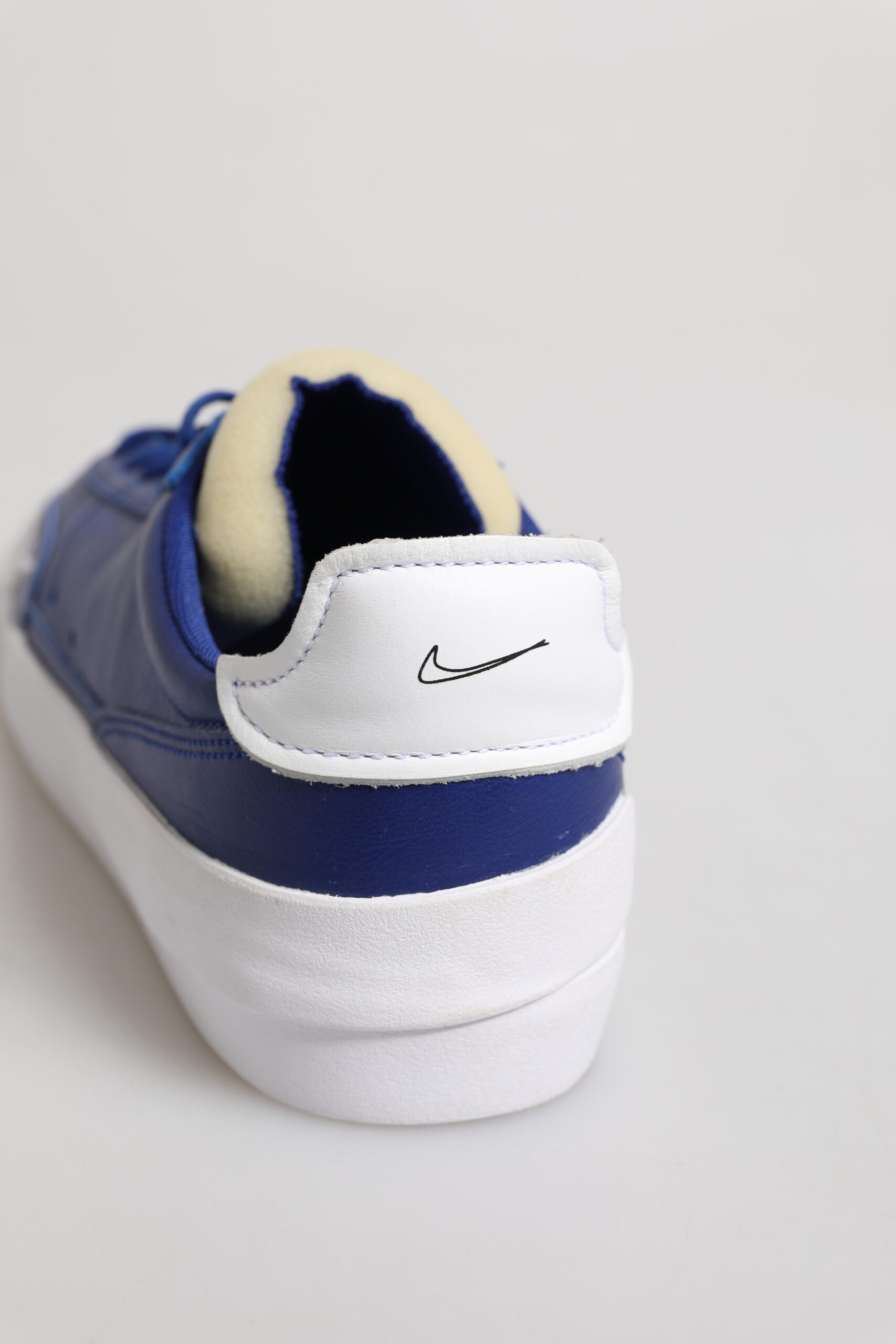 Blue and white sneaker with a yellow logo on the side