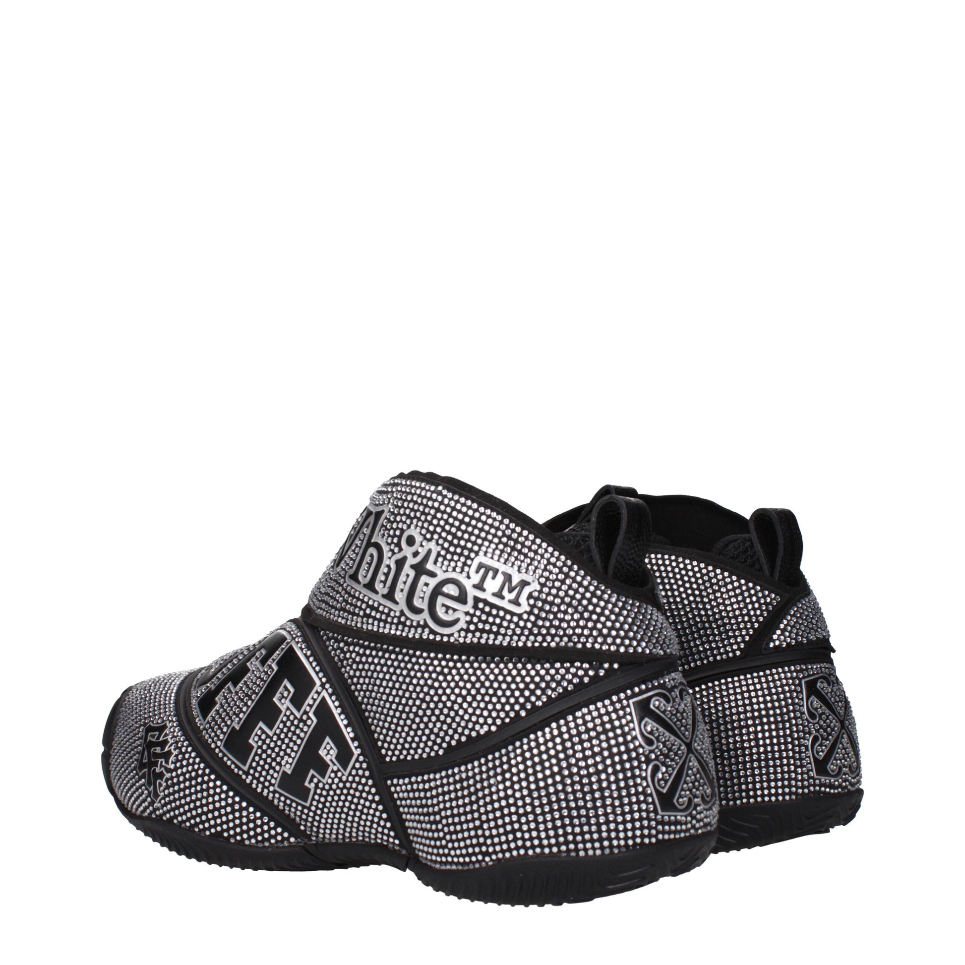 Pair of black and white sneakers with textured pattern, laces, and soles