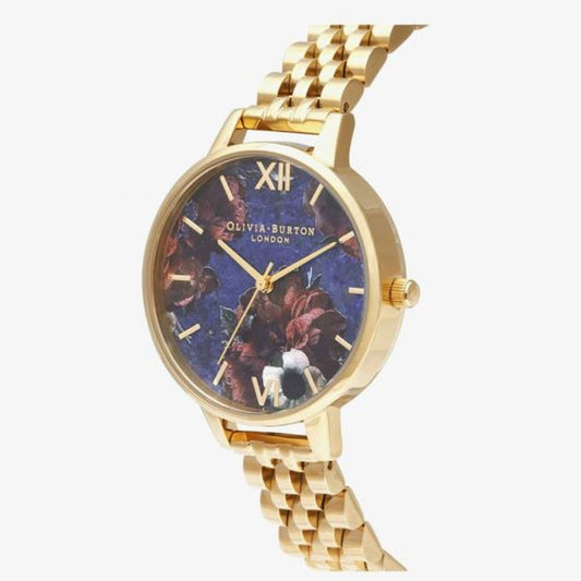 A gold stainless steel watch with a blue face featuring an image of a dog and the brand name "Olivia Burton" on the dial
