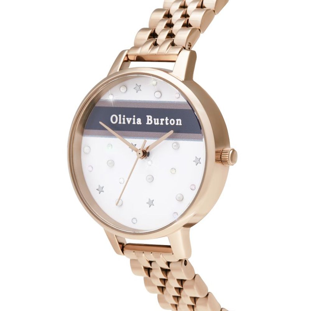 A gold tone watch with a white face featuring black text, sparkling stars and a name