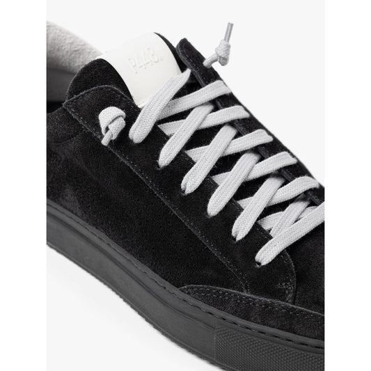 Black velvet sneaker with white laces and a label on the tongue
