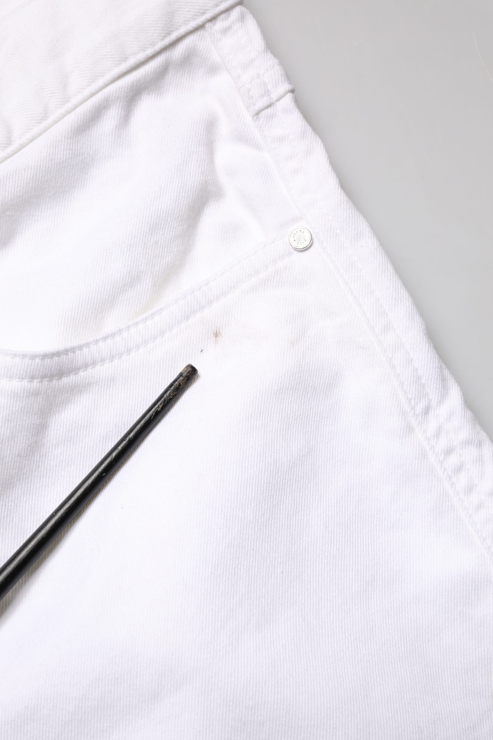 White pants with a button on the waistband